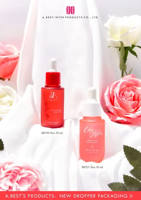 ขวดดรอปเปอร์ ขนาด 30 ml คู่กับฝาดรอปเปอร์สีส้ม และสีแดง ของทางบริษัทเอ.เบสท์ อินเตอร์ โปรดักส์ มีขวดทรงกลมบ่าตัดสีแดง และขวดทรงบ่าตัดก้นมนสีส้ม พิมพ์ลวดลายสีขาวเป็นตัวหนังสือบนขวด วางบนผ้าสีขาว ที่มีดอกกุหลาบสีชมพูและสีขาวรอบๆ