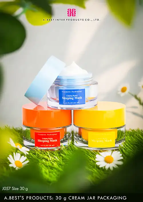 กระปุกครีม 30 g สีฟ้าเปิดฝาสีฟ้า ด้านในกระปุกมีเนื้อครีมสีขาว วางบนกระปุกสีส้ม และสีเหลืองวางบนพื้นหญ้าสีดขียวที่มีดอกเดซี่อยู่โดยรอบ