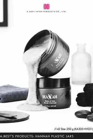 กระปุกสีดำด้านขนาด 250 g ฝาครอบอลูมิเนียมสีดำด้าน ของบริษัทเอ.เบสท์ อินเตอร์ โปรดักส์ จำกัด วางบนพื้นสีขาว ที่มีกระปุก ด้านบนเทเนื้อสครับสีเทาไหลลงมาโดนกระปุกด้านล่าง ซ้ายมือมีผ้าสีเทาเข้มวาง และขวามือมีถ่าน และหินสีดำ ด้านหลังกระปุกมีขวดโหลแก้ววางอยู่