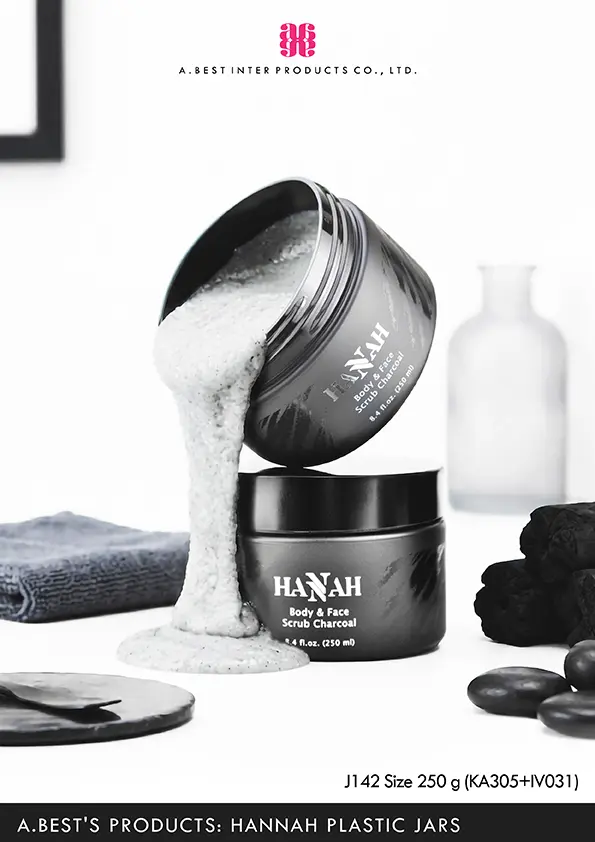 กระปุกสีดำด้านขนาด 250 g ฝาครอบอลูมิเนียมสีดำด้าน ของบริษัทเอ.เบสท์ อินเตอร์ โปรดักส์ จำกัด วางบนพื้นสีขาว ที่มีกระปุก ด้านบนเทเนื้อสครับสีเทาไหลลงมาโดนกระปุกด้านล่าง ซ้ายมือมีผ้าสีเทาเข้มวาง และขวามือมีถ่าน และหินสีดำ ด้านหลังกระปุกมีขวดโหลแก้ววางอยู่