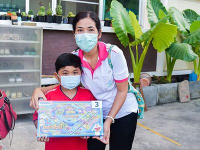 ลูกของพนักงาน เอ.เบสท์ อินเตอร์ โปรดักส์ ยืนถือของขวัญจับฉลากในกิจกรรมวันเด็กแห่งชาติ 2566