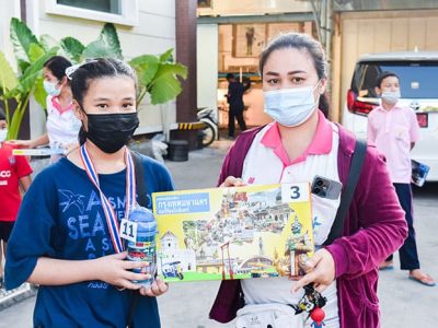 ลูกของพนักงาน เอ.เบสท์ อินเตอร์ โปรดักส์ ยืนถือของขวัญจับฉลากในกิจกรรมวันเด็กแห่งชาติ 2566